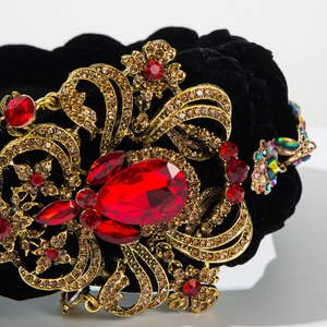 Détail d'un serre-tête en velours baroque avec cristaux rouges et filigrane en métal doré