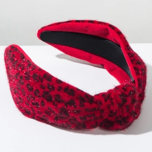 Détail d'un serre-tête en peluche rouge léopard avec nœud et doublure intérieure antidérapante