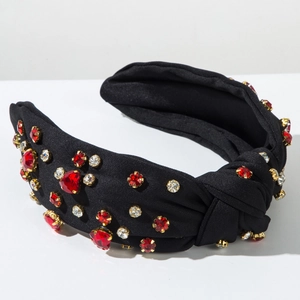 Detail of vintage knotted headband with sparkling red and clear crystals on black silk