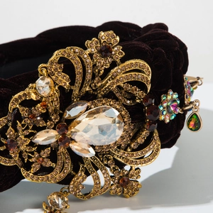 Gros plan du serre-tête en velours tressé avec fleurs en cristal et détails baroques