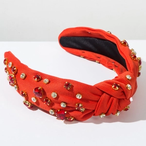 Close-up of a red knotted headband with sparkling red heart rhinestones and gold claws