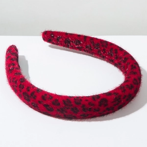 Close-up of fluffy red leopard print headband with soft velvet texture and thick design