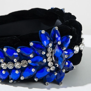 Detailed close-up of dark blue crystal flower pattern on a black velvet headband