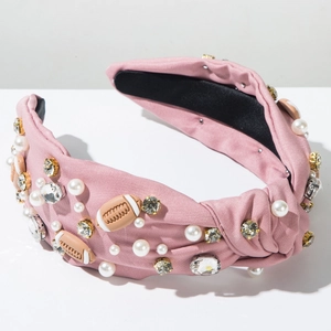 Detailed view of pink knotted headband featuring rhinestones, pearls, and rugby decor