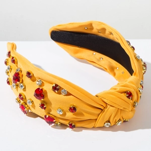 Detail of yellow fabric headband featuring red heart rhinestones and non-slip inner lining