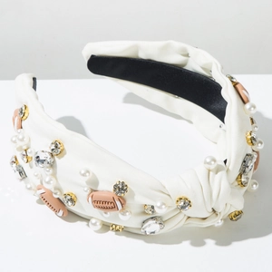 Close-up of knotted headband with white rhinestones, pearls and rugby ball charms