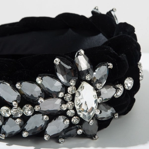 Detailed view of hand-sewn crystals and rhinestones on black velvet braided headband