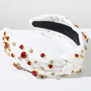 Detail of white fabric headband with red heart rhinestones and gold claw setting