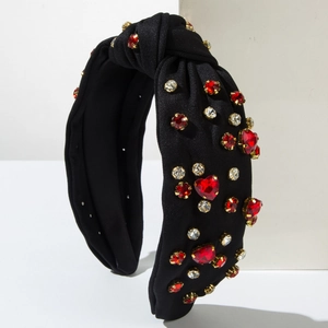 Close-up of sparkling red heart rhinestones on a black knotted headband accessory