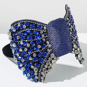 Détail de strass bleu roi et blancs scintillants sur un serre-tête large à nœud