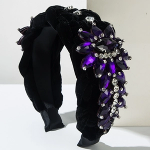 Velvet braided headband with purple gemstones and crystals on a white pedestal