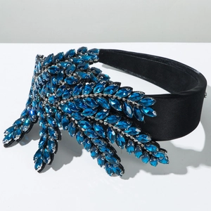 Detail eines luxuriösen Haarreifs mit marineblauen Kristallen und Samt-Textur
