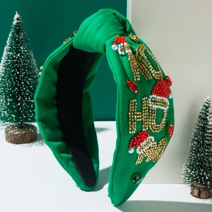 Close-up of green knotted headband with 'HO HO HO' beadwork and sparkling rhinestones