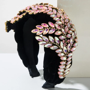 Dettaglio macro di strass rosa e motivi a foglia d'oro sulla fascia in velluto nero