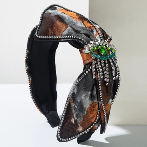 Détail du serre-tête vintage avec grand nœud en strass et pendentif œil de protection