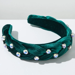 Detail of green velvet braided headband with large sparkling rhinestones and texture