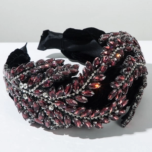 Détail d'un serre-tête en velours noir orné de cristaux bordeaux en forme de feuilles