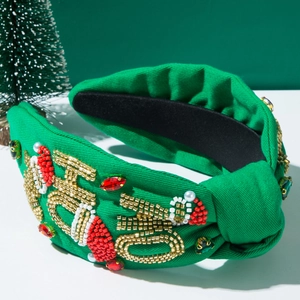 Close-up of green Christmas headband featuring beaded festive letters and faux pearls