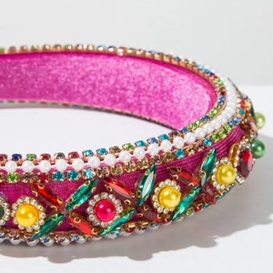 Détail d'un serre-tête de luxe en velours avec strass colorés et perles brodées