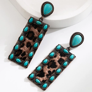 Detail view of retro bronze earrings with leopard texture and turquoise gemstone inlay