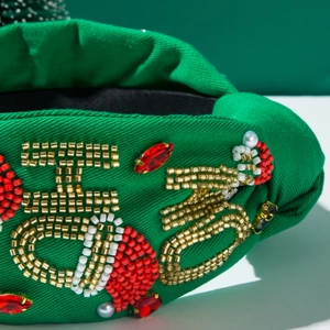 Close-up of green Christmas headband with handcrafted HO HO HO bead embroidery