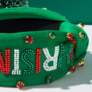 Detail of Christmas headband with green fabric, beaded letters and colorful rhinestones
