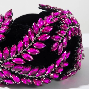 Détail de feuilles de cristal rose sur un serre-tête en velours noir pour soirée