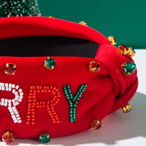 Detail of red knotted headband with festive gemstone beads and Merry Christmas lettering