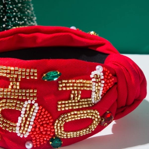 Detailed close-up of Christmas headband featuring hand-beaded HO HO HO lettering and pearls