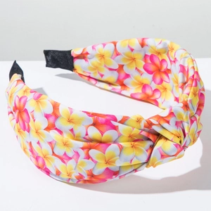 Detail of bohemian floral knotted headband showing yellow plumeria pattern and soft fabric