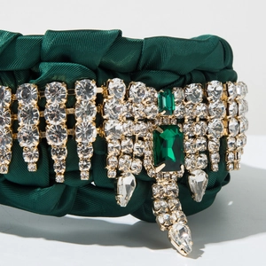 Dettaglio macro della fascia intrecciata verde smeraldo con strass di lusso e cristalli