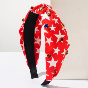 Detail of red knotted headband with white stars and sparkling colorful rhinestones