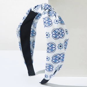 Detail des blauen Evil-Eye-Prints und des Knotendesigns auf weißem Canvas-Haarband