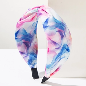 Bandeau bohème en tissu tie-dye avec nœud rose et bleu sur support blanc