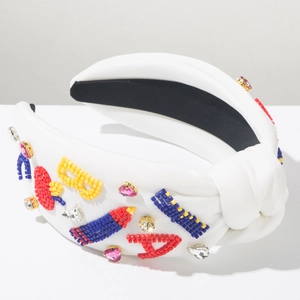 Detail of white beaded headband with colorful rhinestones and embroidered letters