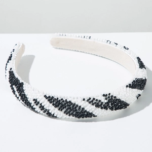 Vue détaillée des motifs en perles noires et blanches sur le serre-tête rembourré