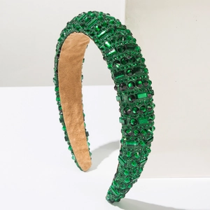 Détail d'un serre-tête large de luxe orné de cristaux verts et doublure en velours