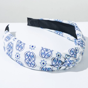 Detail eines weißen Knotenstirnbands mit blauem Evil-Eye-Print und rutschfestem Innenfutter