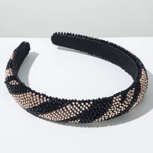 Détail d'un serre-tête perlé à la main avec motifs floraux noirs et dorés élégants