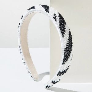 Détail de motifs en perles noirs et blancs faits main sur un bandeau large rembourré