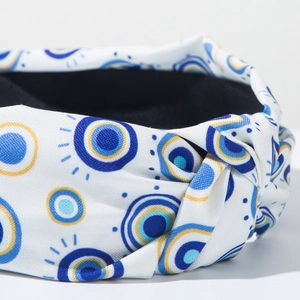 Nahaufnahme des Knotens am breiten Evil Eye Haarband mit blau-gelbem Druckmuster