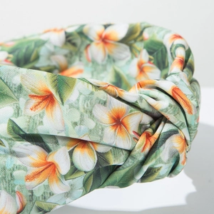 Detailed close-up of tropical floral print knot headband with green leafy patterns