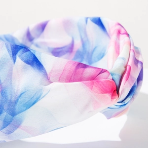 Détail macro d'un serre-tête bohème en tissu tie-dye avec nœud croisé et imprimé coloré