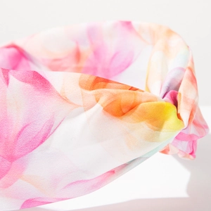 Détail d'un bandeau bohème avec motifs floraux tie-dye et design croisé élégant