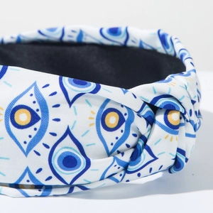 Detailansicht der Stofftextur und des geknoteten Evil-Eye-Musters auf dem breiten Stirnband