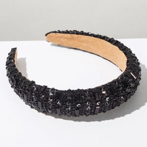 Détail de cristaux noirs cousus main sur un bandeau large rembourré de luxe