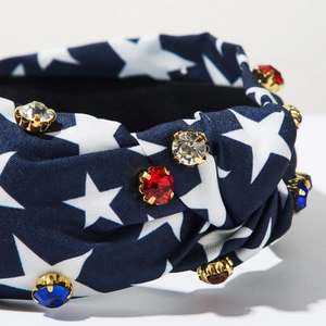 Close-up of navy blue twisted headband with white stars and red, white, and blue rhinestones