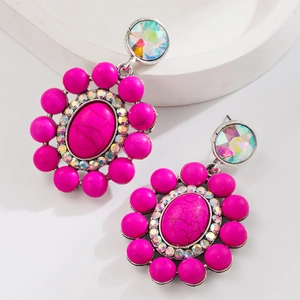 Detail van boheemse magenta stenen oorbellen met turquoise textuur en kristallen