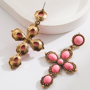 Detail of vintage gold cross earrings with turquoise inlay on a decorative tray