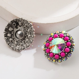 Macro view of vintage round earrings with vibrant fuchsia beads and colorful center stone
